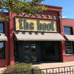The storefront of Mansfield gift shop "the hoot." Red brick building with striped awnings.